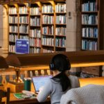 A learner reading at a desk in a sunlit library