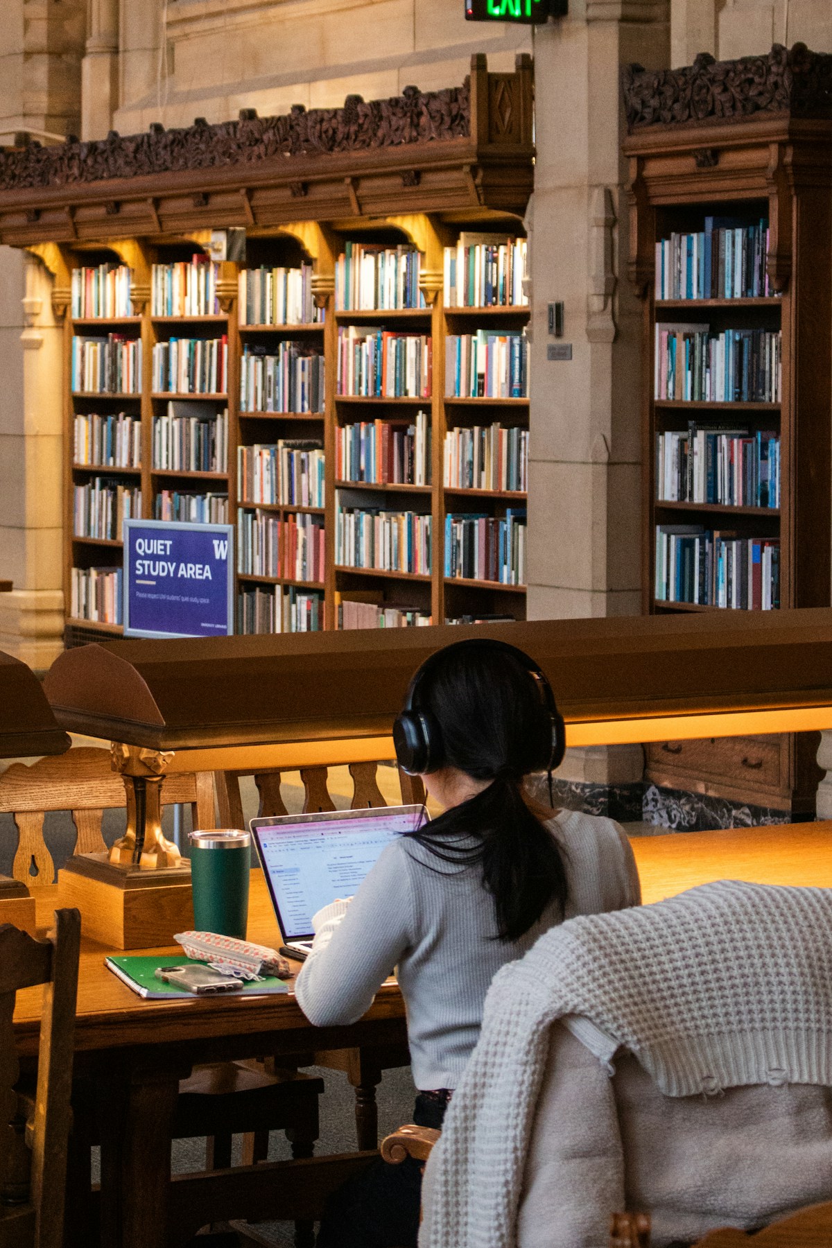 A learner reading at a desk in a sunlit library